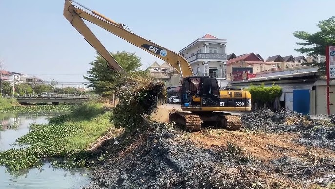 Excavator clearing vegetation from a Florida canal bank
